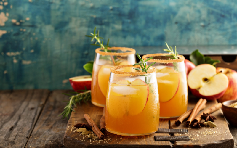 Fall cocktails with apple slices, cinnamon sticks, and rosemary garnish - perfect for October liquor store specials in Fort Collins